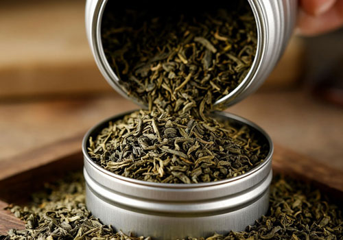 Зелёный чай насыпают из жестяной банки